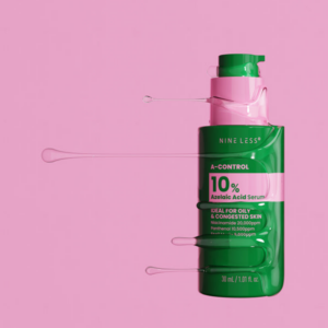 NINE LESS Azelaic Acid Serum bottle lying on pink background with serum texture streaming from pump
