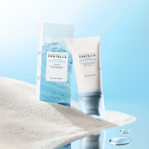 SKIN1004 Madagascar Centella Hyalu-Cica Water-Fit Sun Serum SPF 50 tube with packaging box on sand