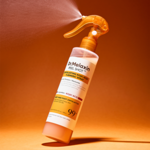 Dr.Melaxin Peel Shot Kojic Acid Turmeric Spray bottle with mist on orange background